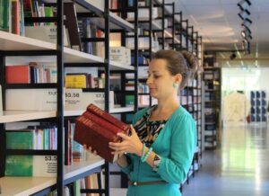 giovane donna davanti ad uno scaffale di una libreria