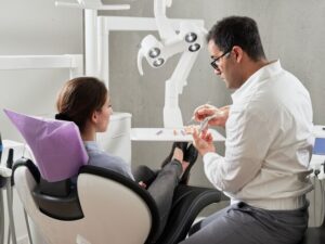 dentista che parla con una paziente seduta sulla sedia