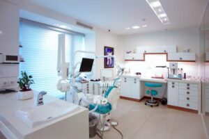 stanza di un dentista con lavello in primo piano e sedia in secondo piano