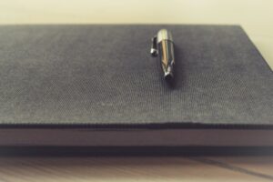 penna appoggiata sopra un quaderno