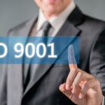 Professionista consulta un documento ISO 9001 in un ufficio tecnico