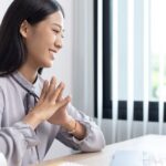 온라인 상담 중인 비즈니스 여성. 노트북 앞에서 미소를 지으며 VIES 보증 관련 절차를 설명하고 있다.