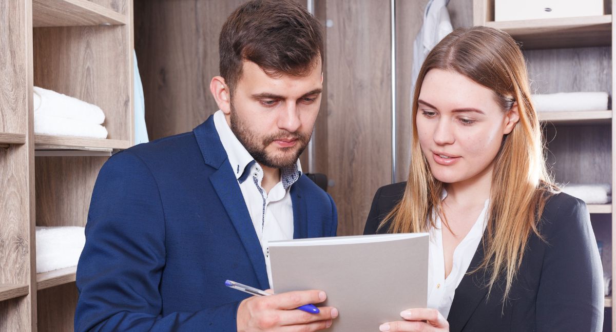 Dois profissionais analisam um documento de garantia VIES num ambiente empresarial, focados nos requisitos legais para operar em Itália.
